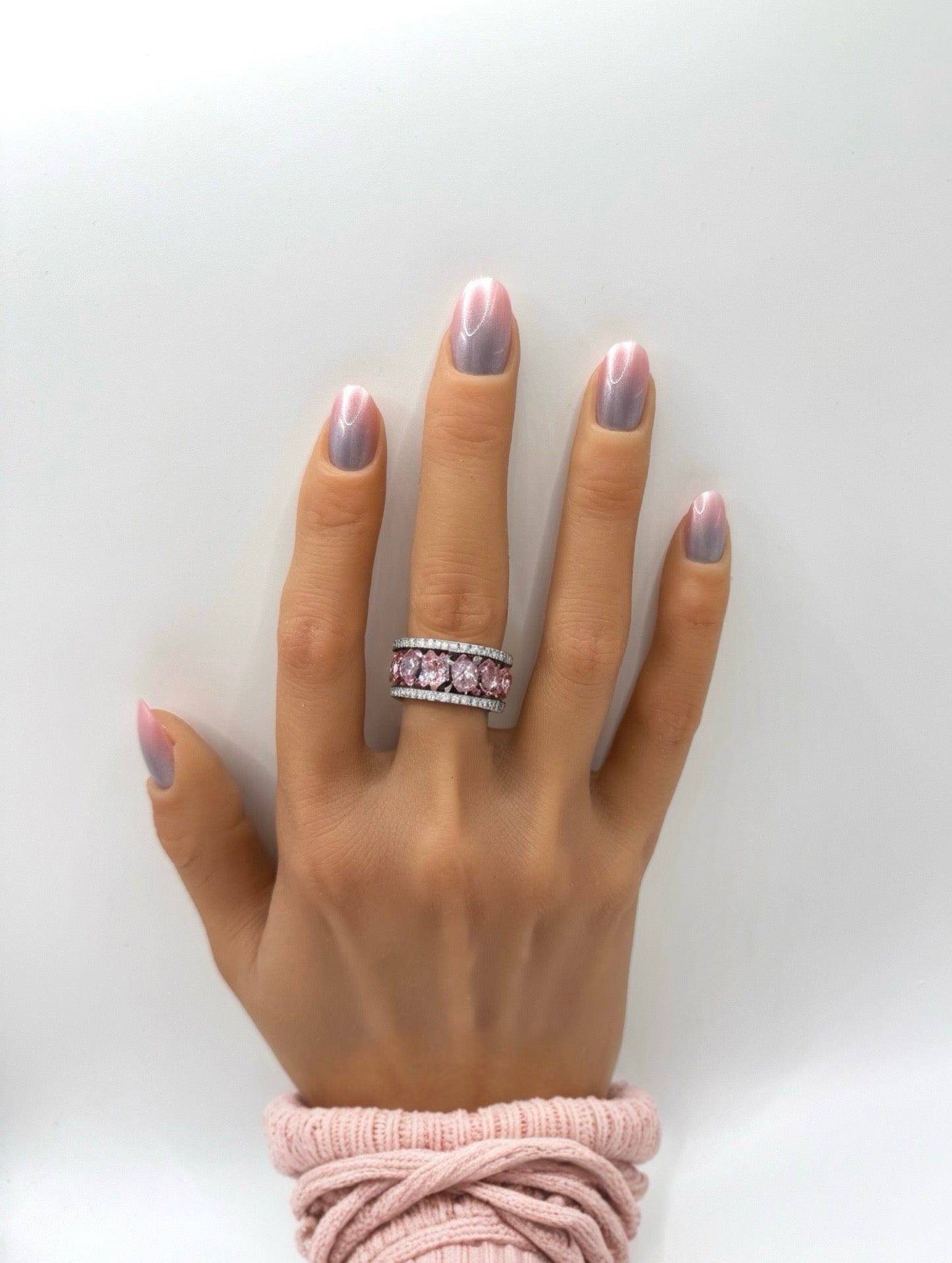 Hand with medium oval iridescent pink press-on nails from Mani in Minutes, set name Pink Aura.
