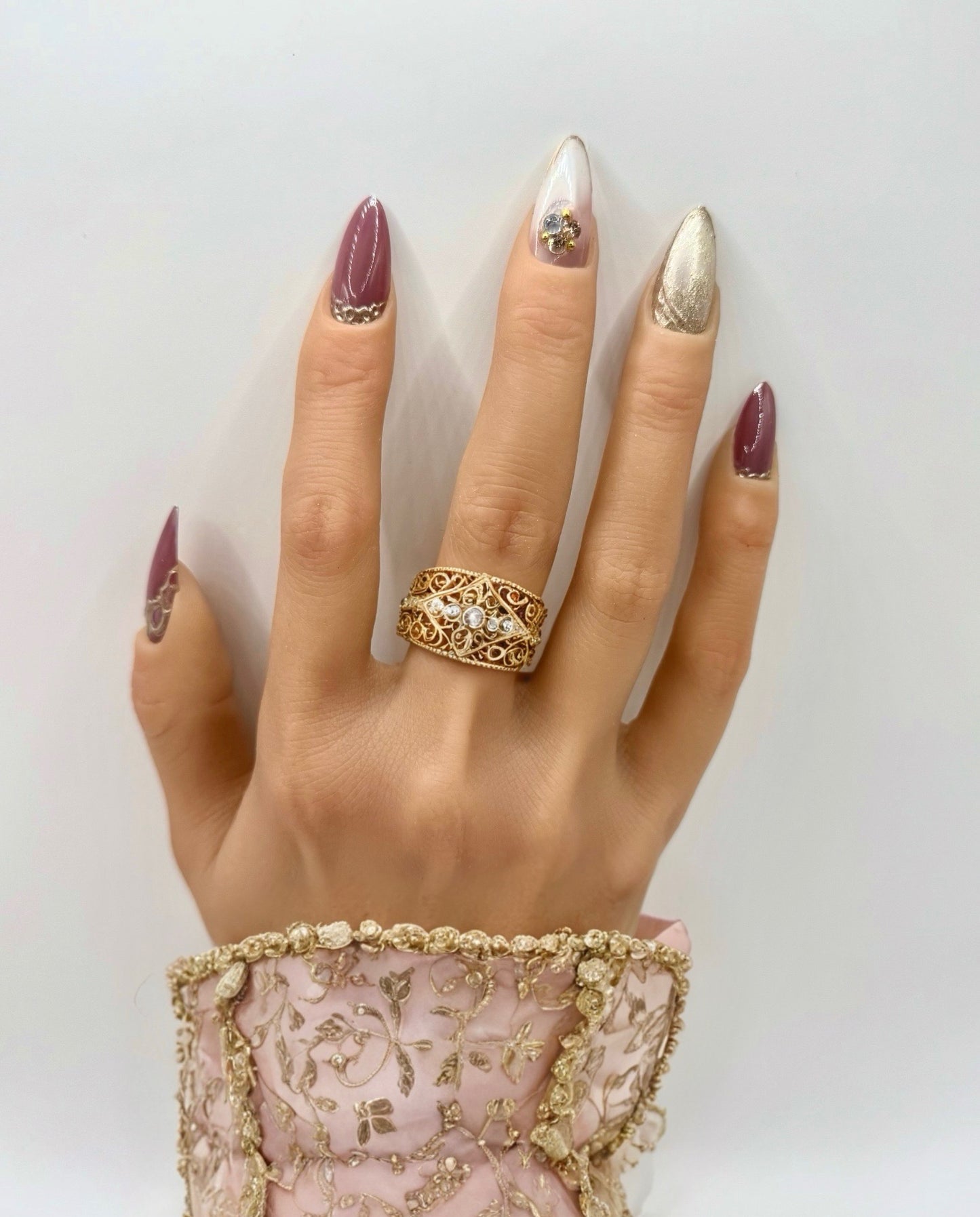 Model wearing Gilded Rose press-on nails – dusty pink nails with gold accents on natural hand