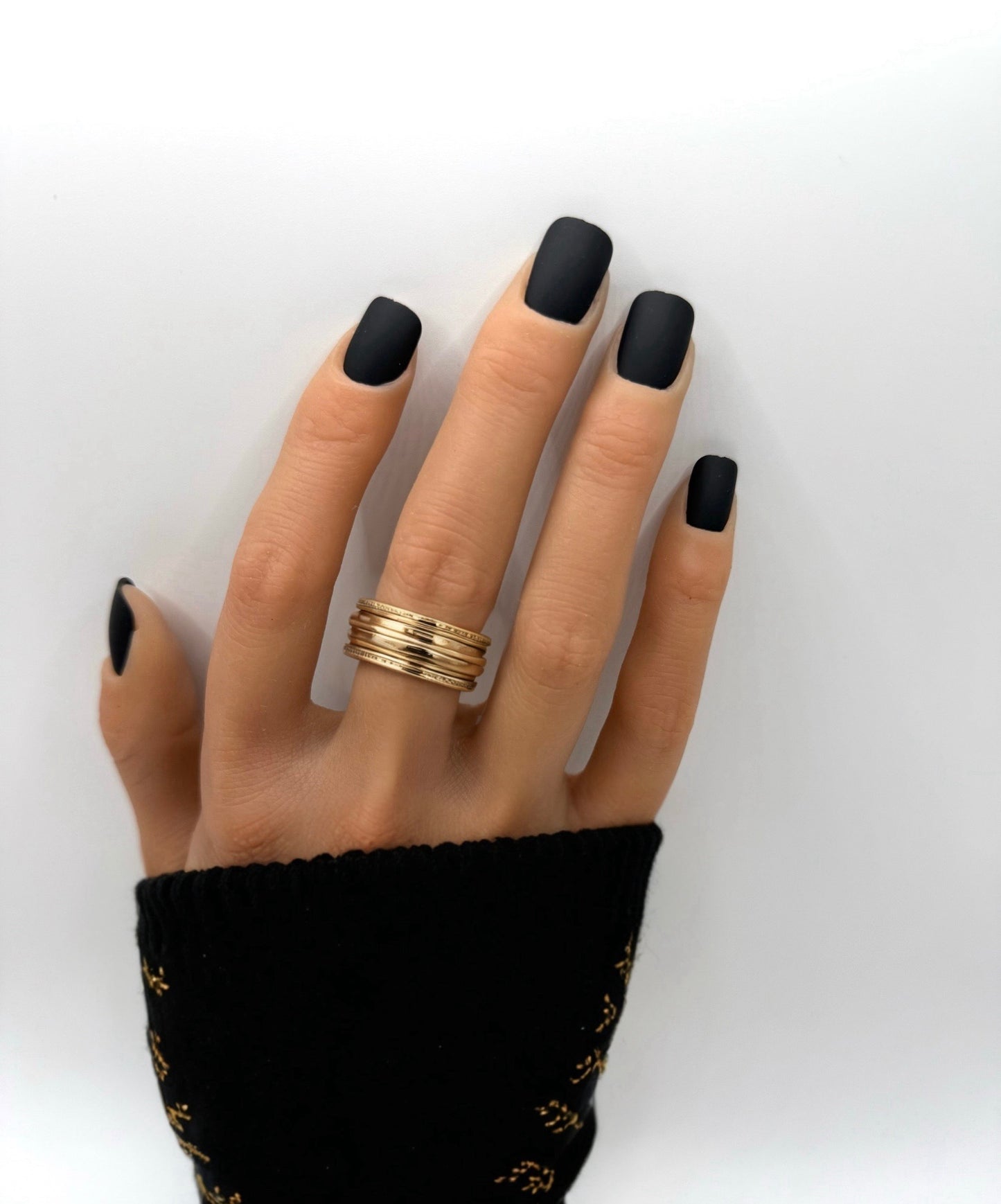 Hand wearing Carbon Crush press-on nails – short square matte black nails