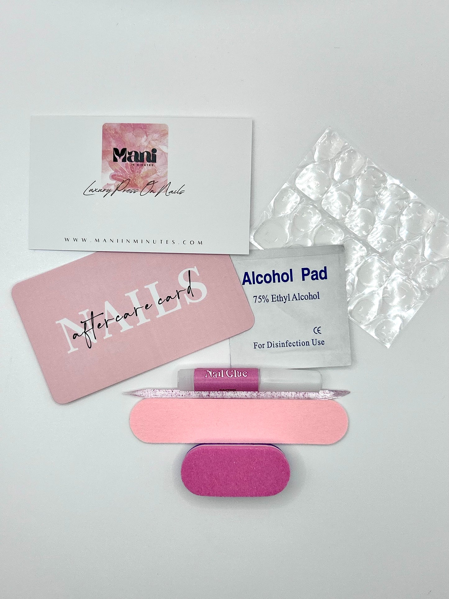 Mani in Minutes nail prep kit including file, buffer, alcohol wipe, cuticle stick, glue, and adhesive tabs