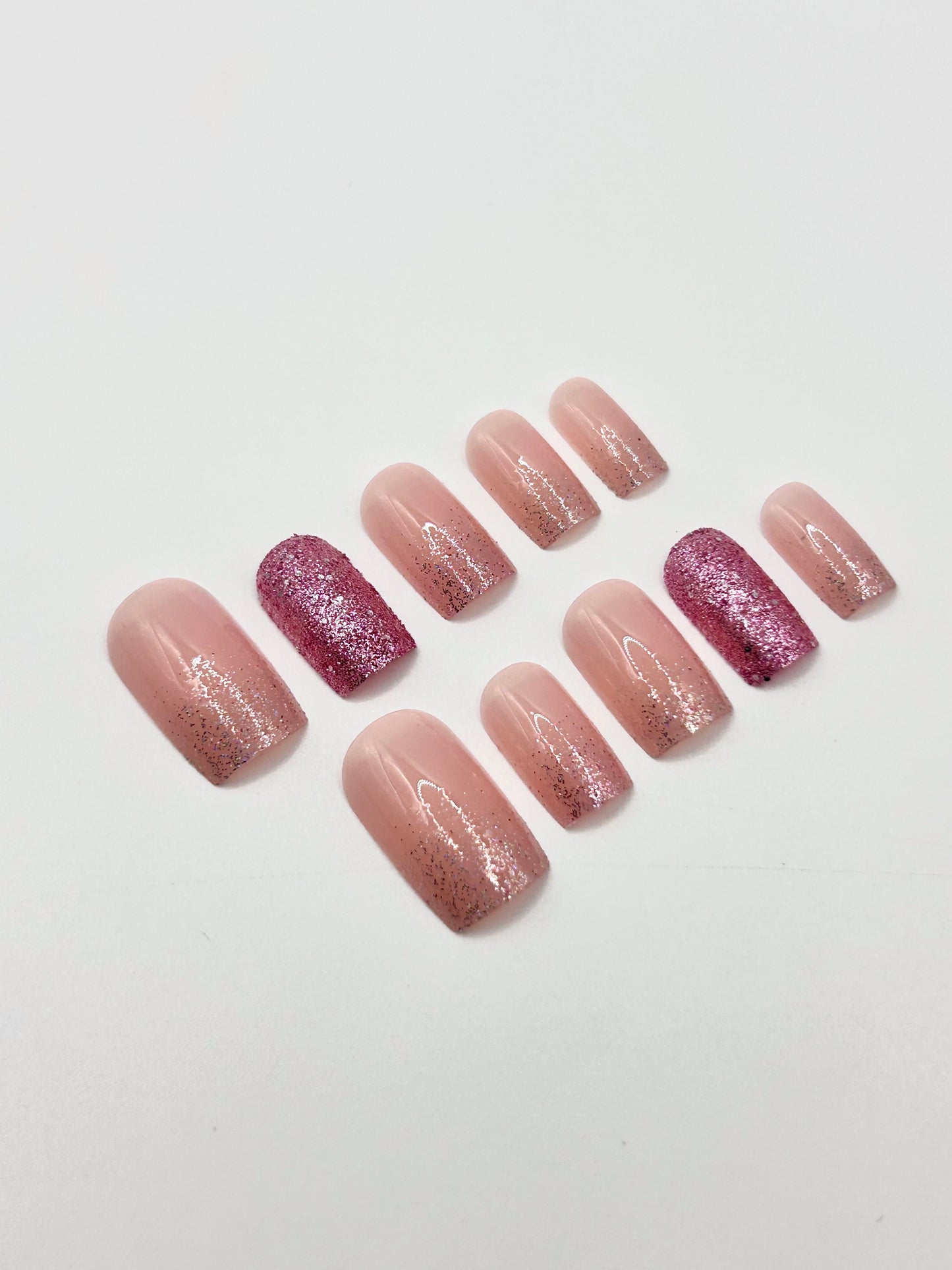 Close-up of glittery pink press-on nails in the Pink Fizz set.