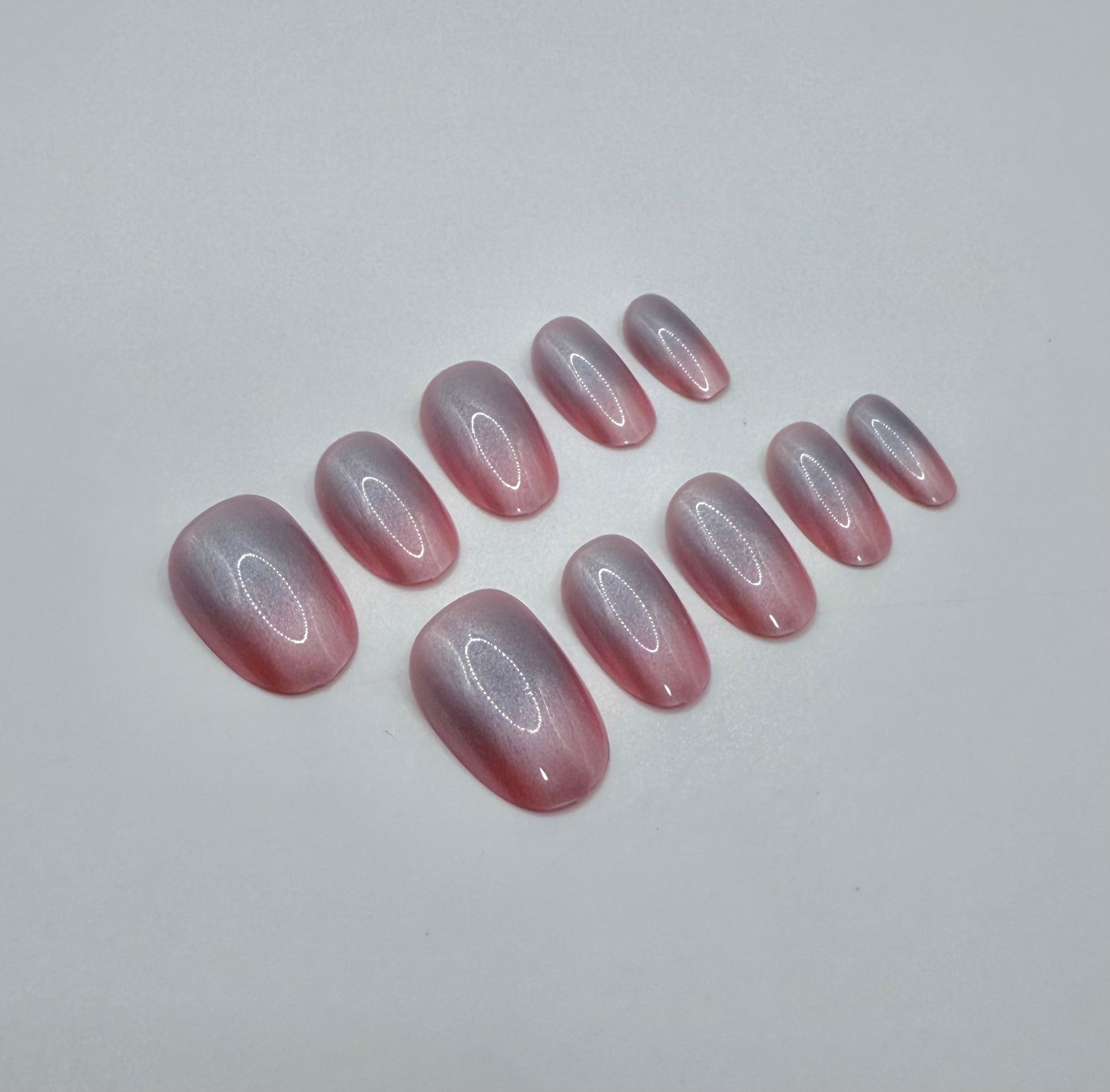 Close-up of glossy pink iridescent nails in the Pink Aura press-on set.