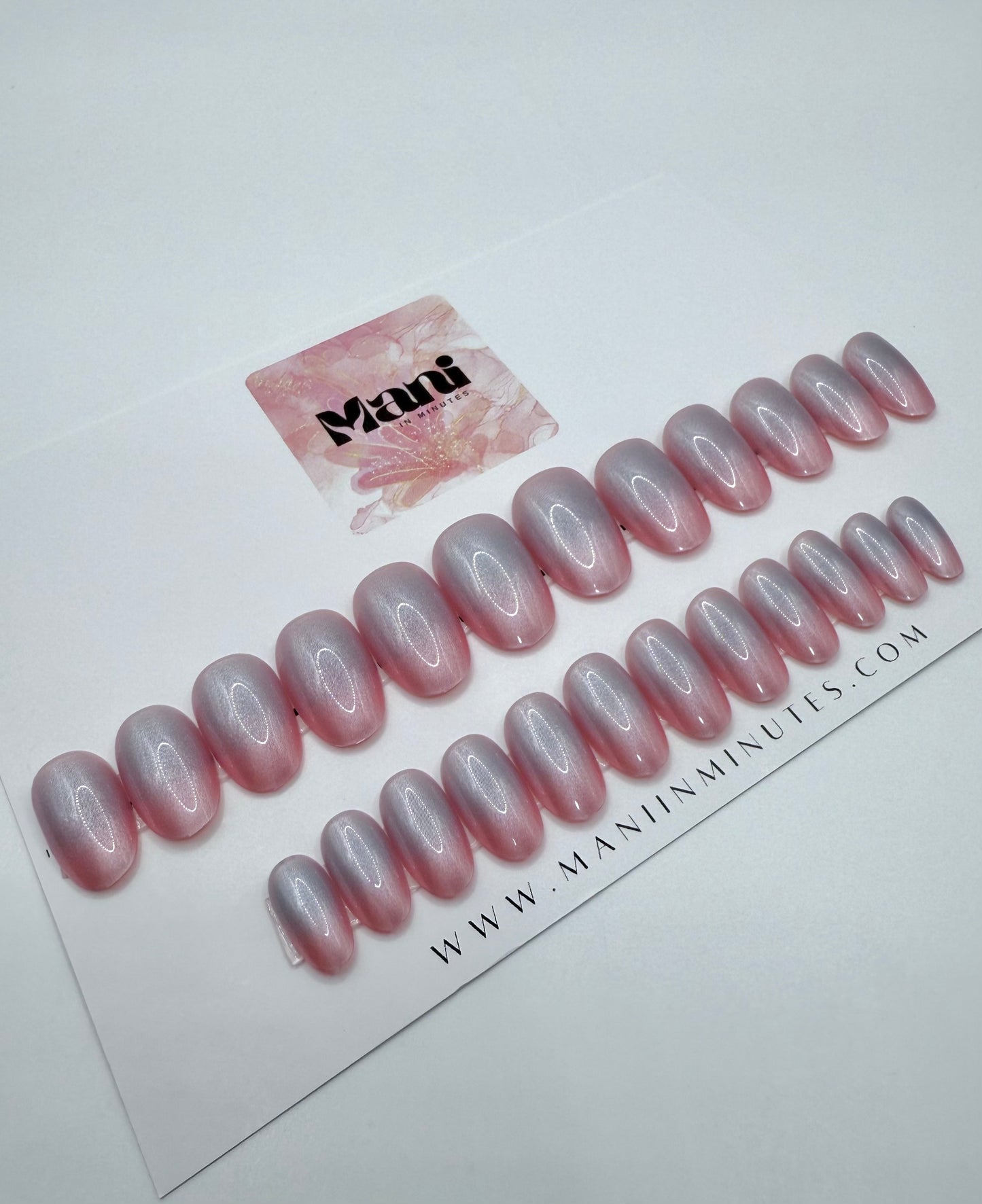 Pink Aura press-on nails with an ombre effect, displayed on branded Mani in Minutes card.