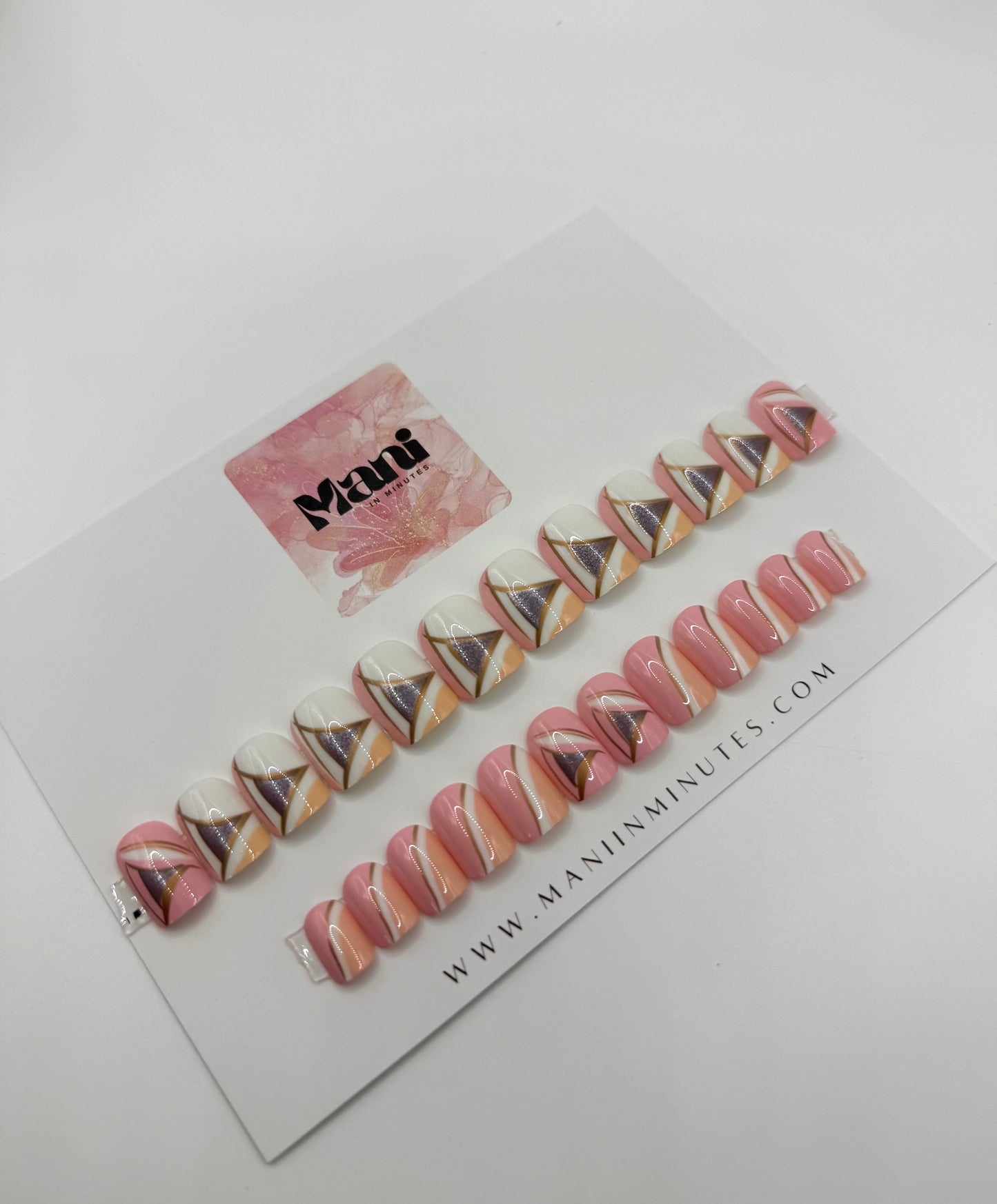 Vogue Lines nail set on Mani in Minutes card – pink geometric press-on nails with white, peach, and pewter detail