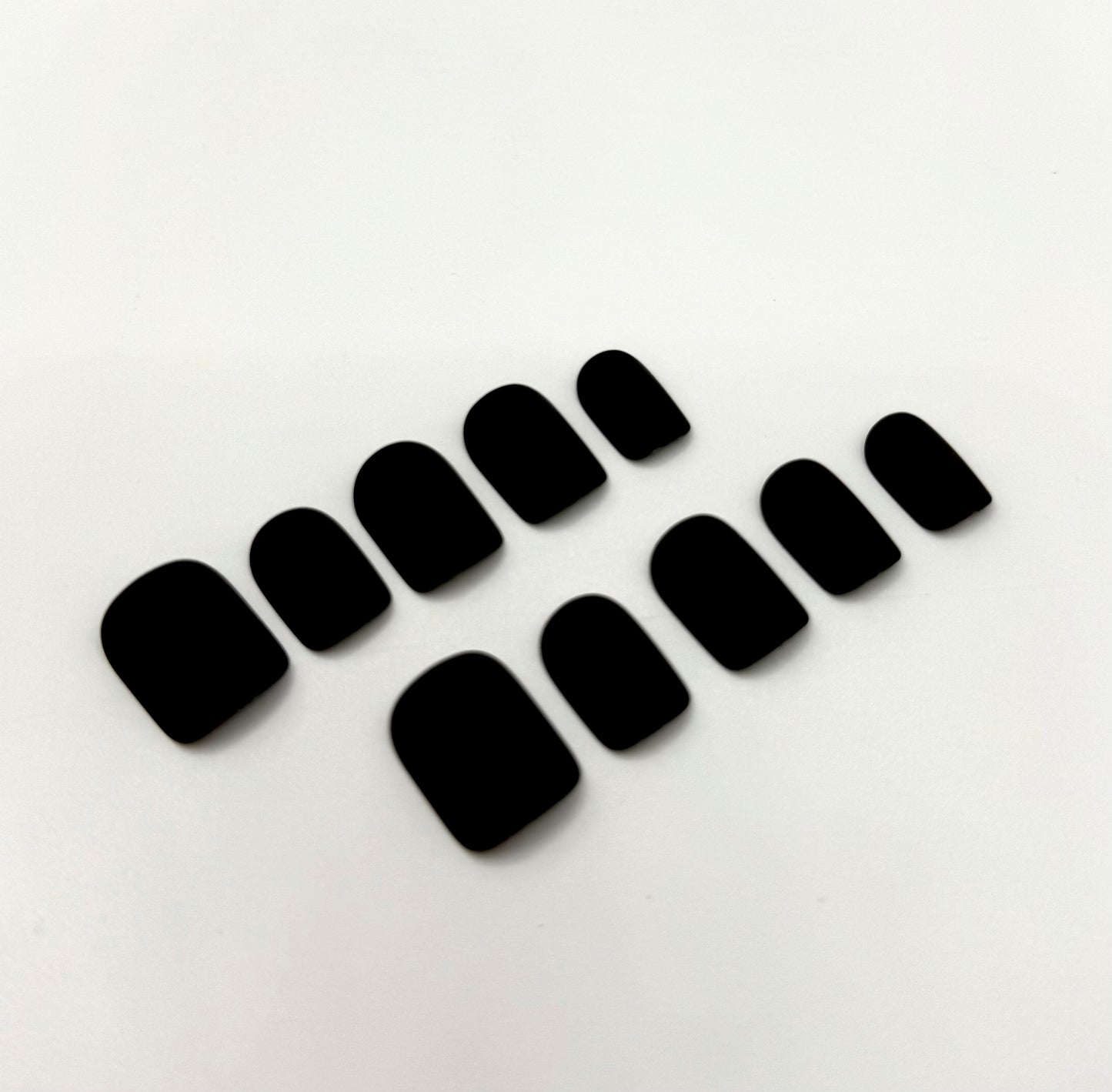 Close-up of Carbon Crush press-on nails showing sleek matte black finish