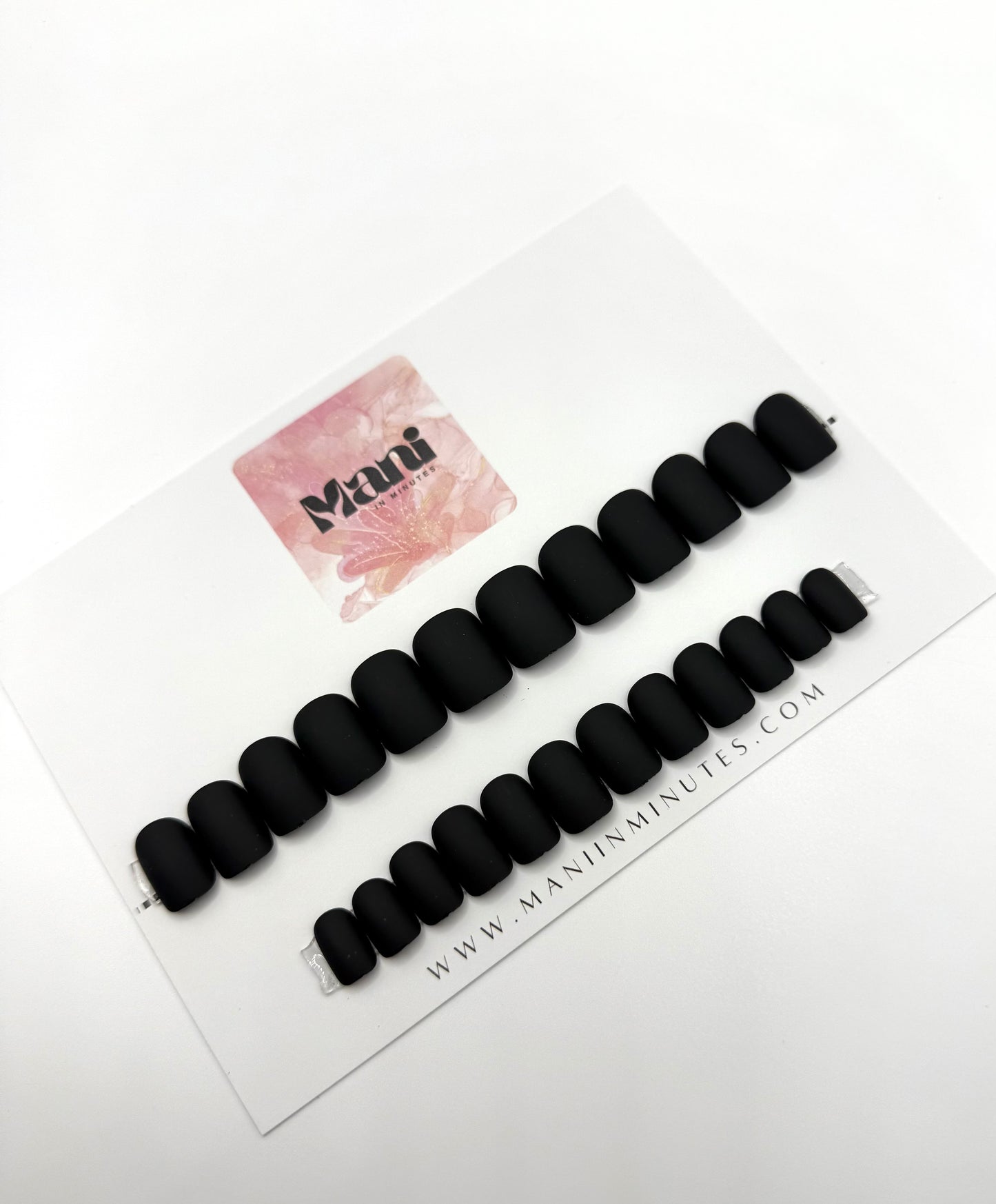 Carbon Crush nail set displayed on Mani in Minutes card – short matte black square nails