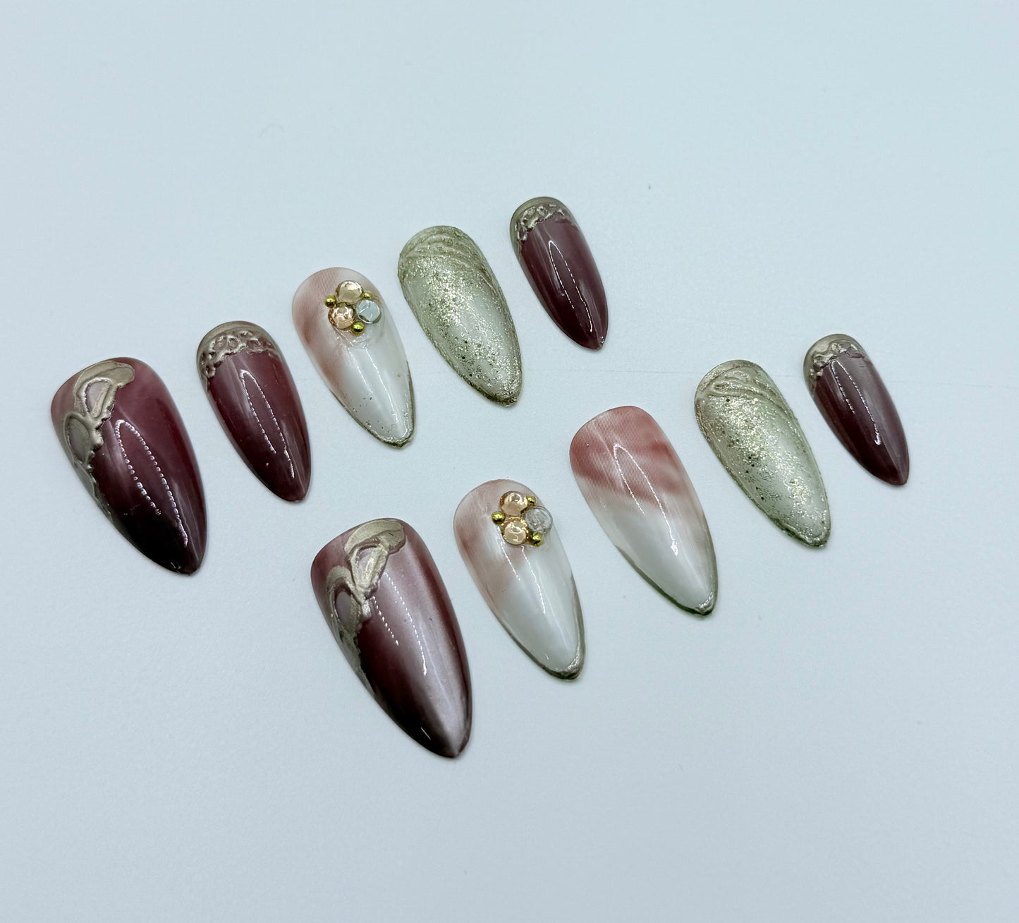 Close-up of Gilded Rose press-on nails showing dusty pink finish and subtle gold accents in almond shape
