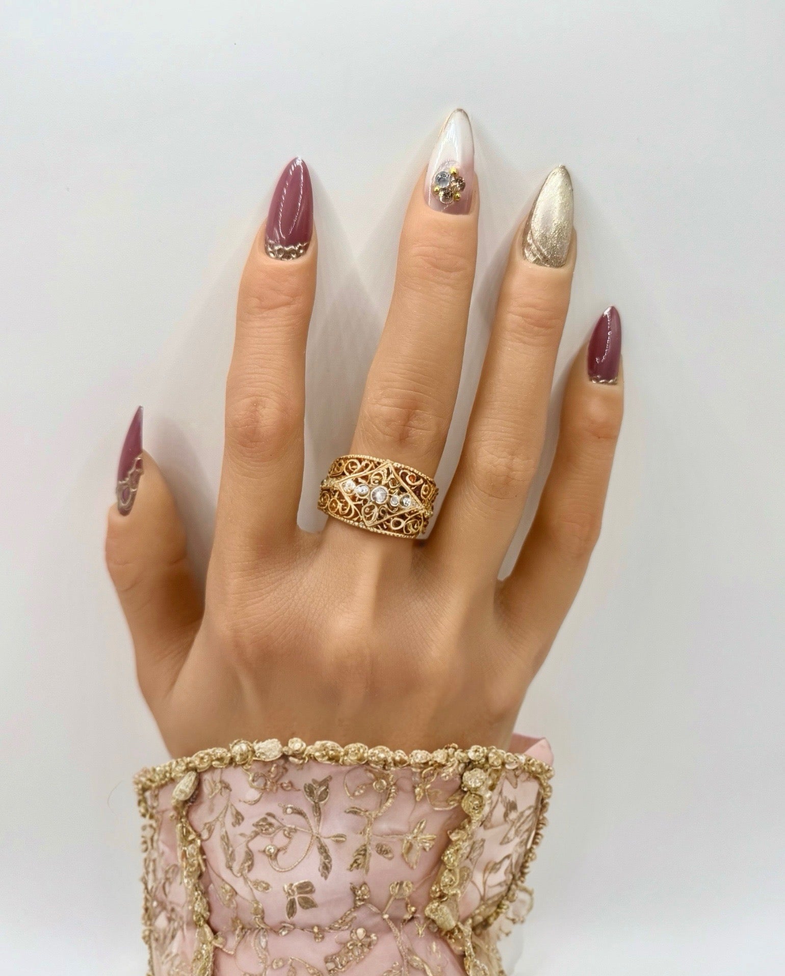 Model wearing Gilded Rose press-on nails –  dusty pink nails with gold accents on natural hand