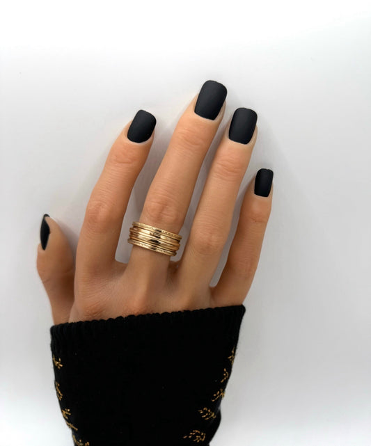 Hand wearing Carbon Crush press-on nails – short square matte black nails