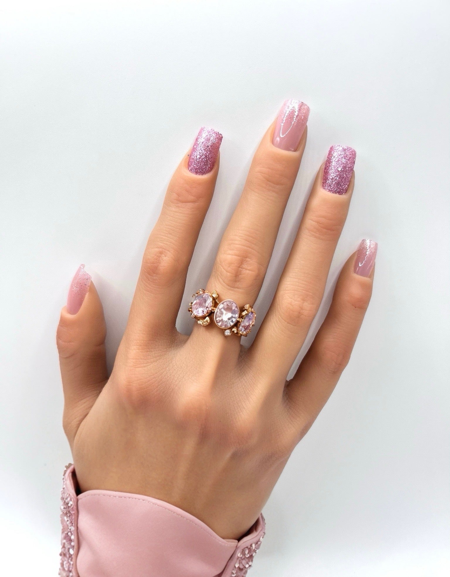 Hand with medium square pink glitter press-on nails from Mani in Minutes, set name Pink Fizz.
