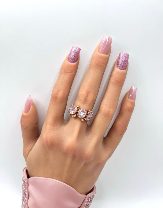 Hand with medium square pink glitter press-on nails from Mani in Minutes, set name Pink Fizz.