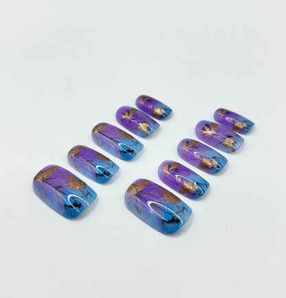 Close-up of the purple and blue floral press-on nails with gold detail in the Fleur de Luxe set.