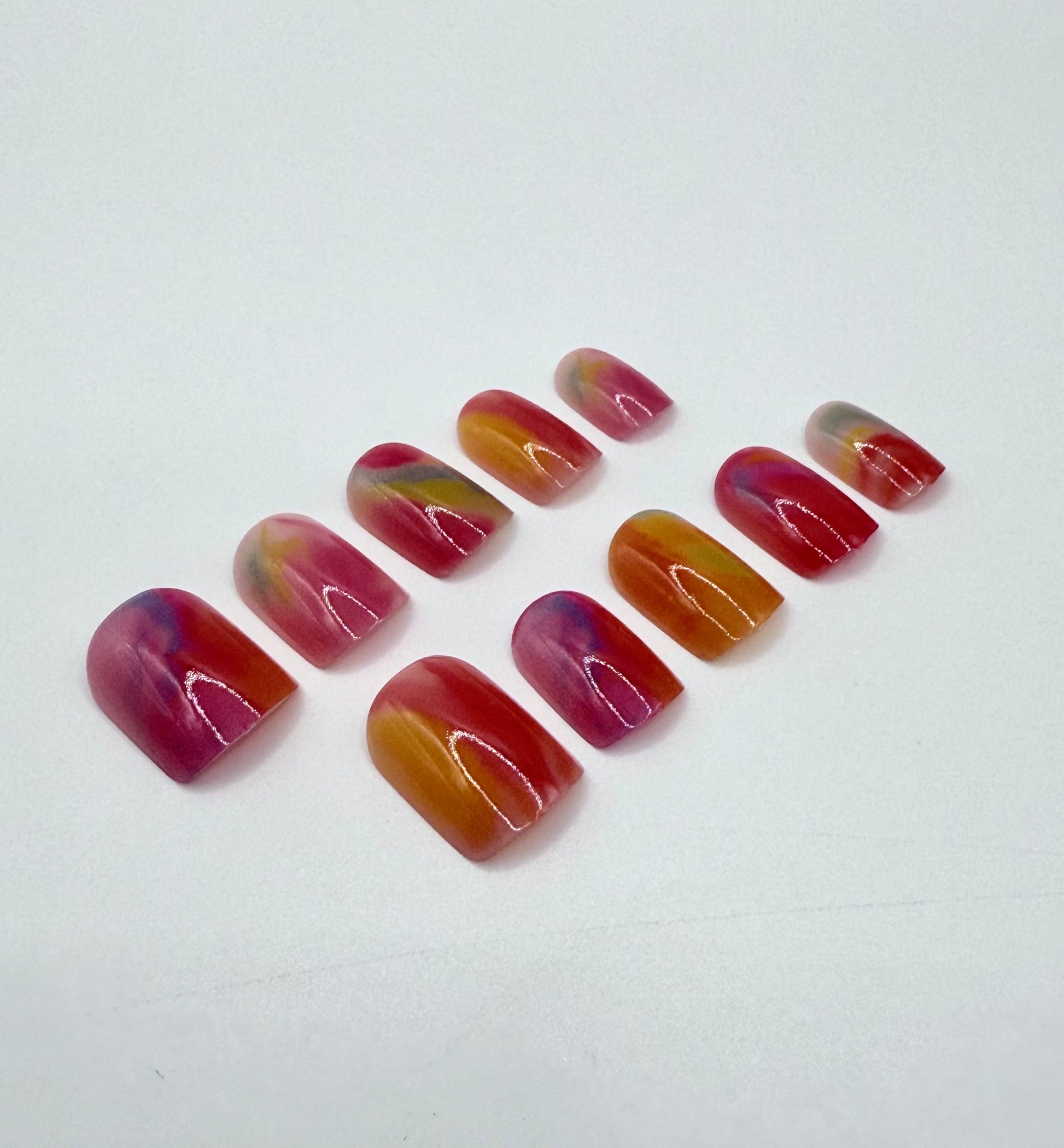Close-up of glazed rainbow swirl nails in the Candy Drop press-on nail set.