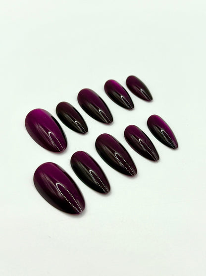 Close-up view of deep berry medium almond nails in the Noir Berry set.