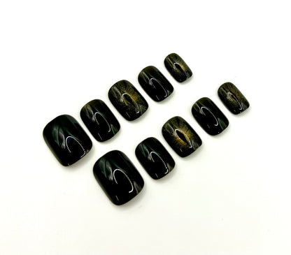 Close-up of Cat Eye press-on nails showing magnetic shimmer accents that resemble a glowing cat’s eye